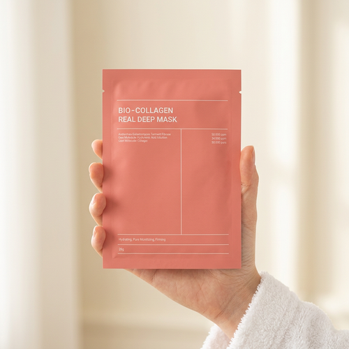 Hand holding a coral pink Bio Collagen Real Deep Mask sachet